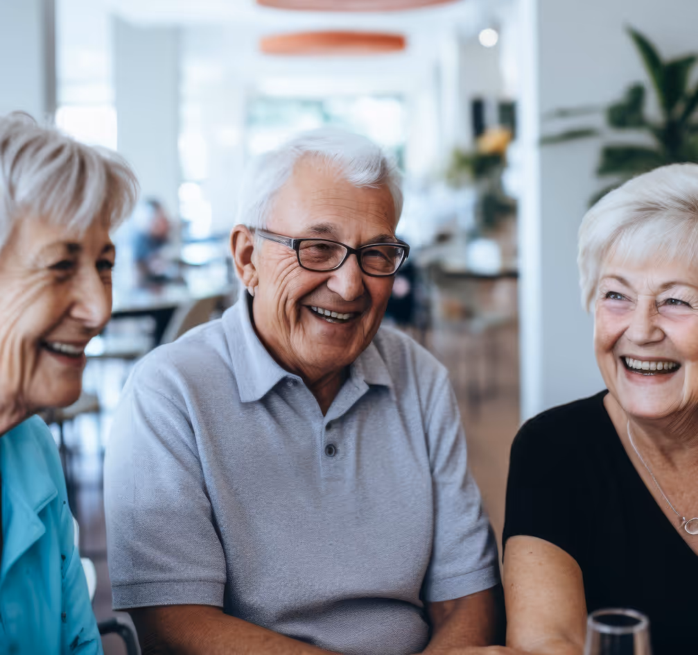 three elderly people sitting together