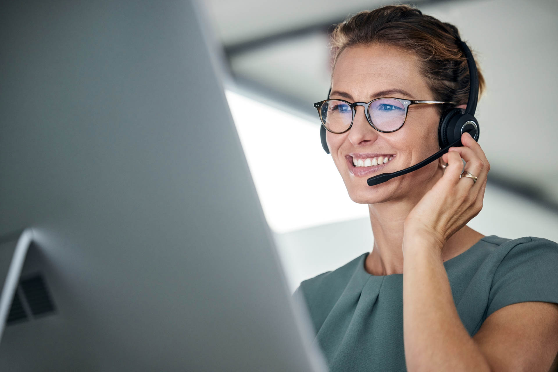 a women with a headset on working on a computer