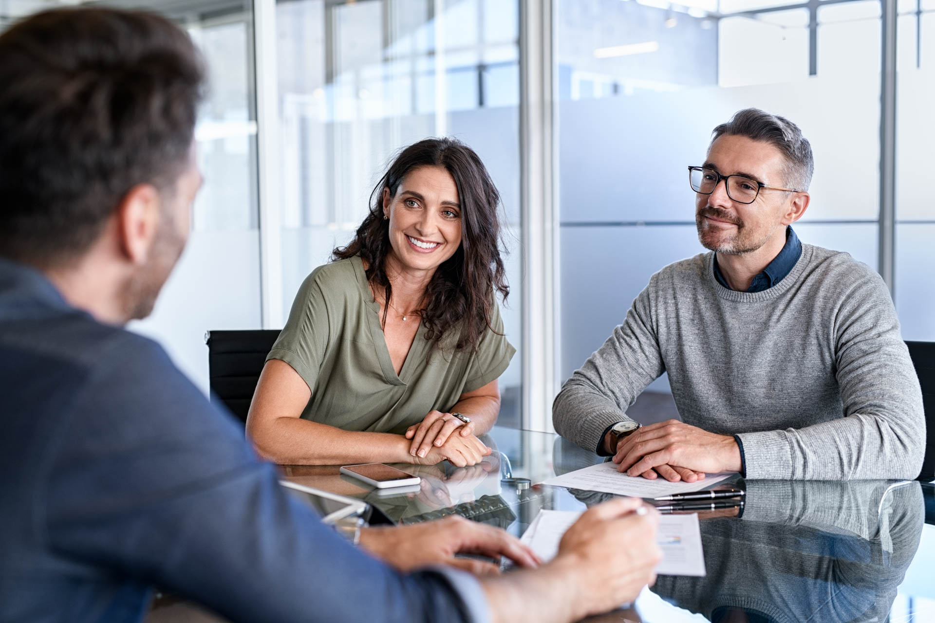 group of 3 people sitting in a meeting