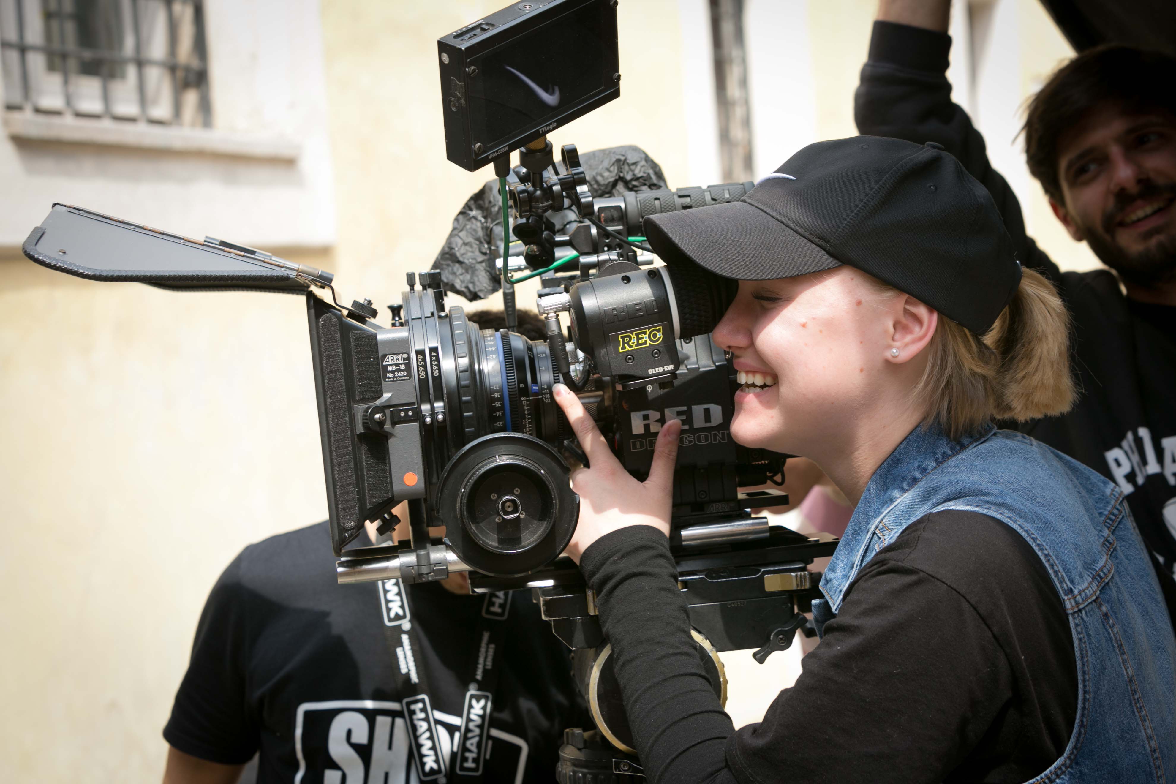 Student holding camera and looking into the lens 