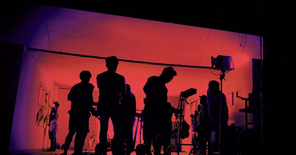 Film crew on set in high contrast red lighting 