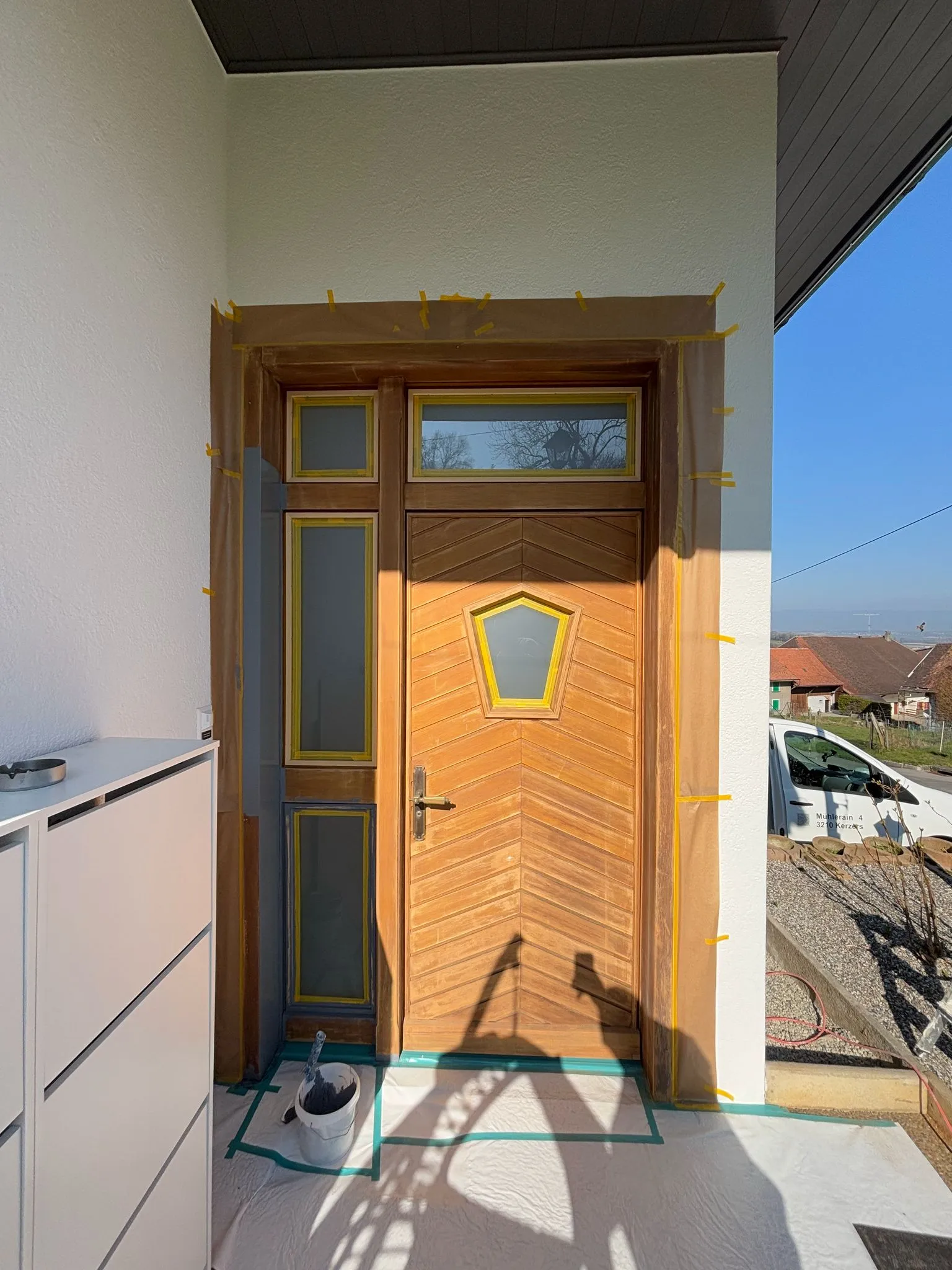 Holztür mit Fenstern, umgeben von Maler-Abdeckpapier und Malerband zum Schutz während Renovationsarbeiten.