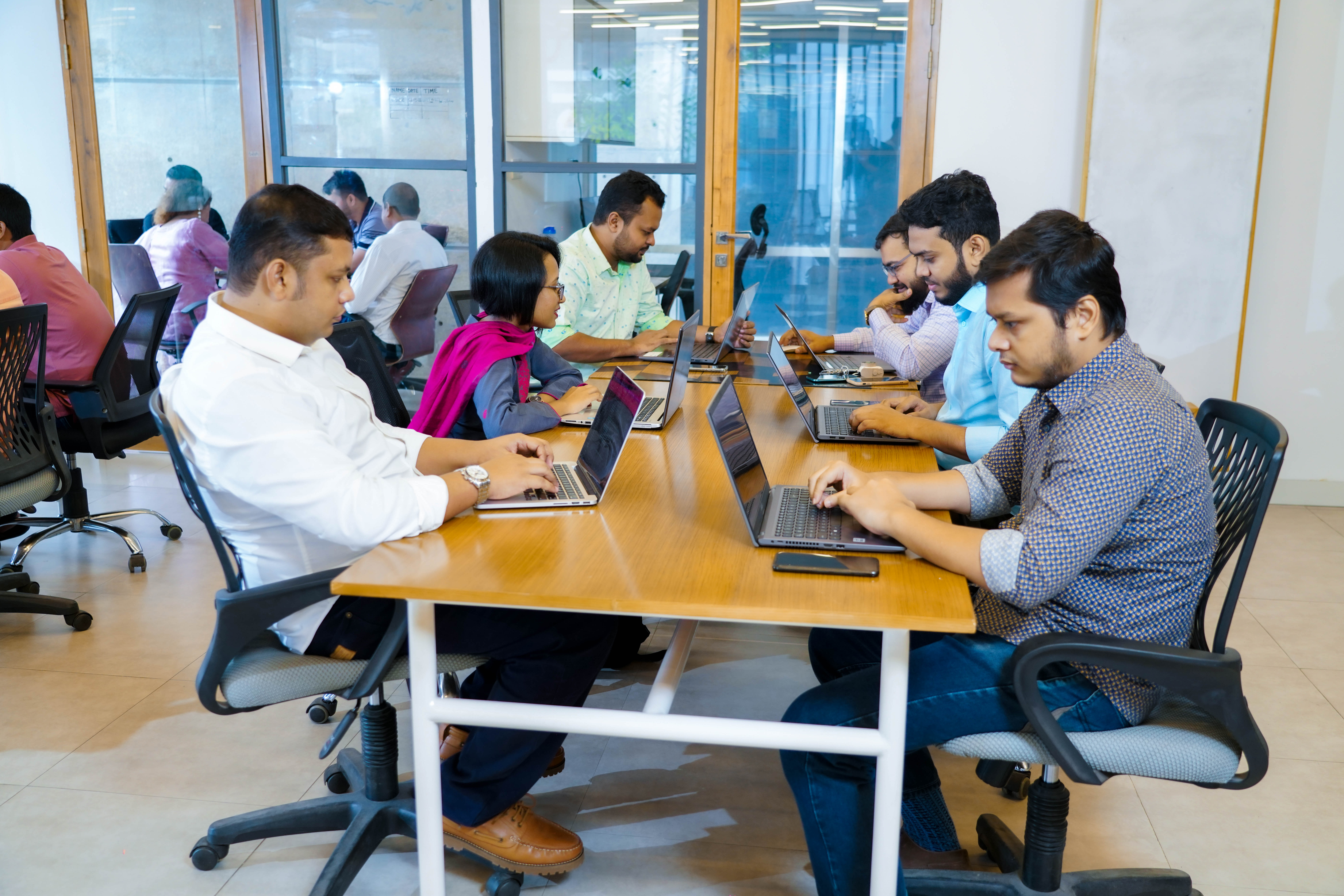 Binate team working together at desks in the office