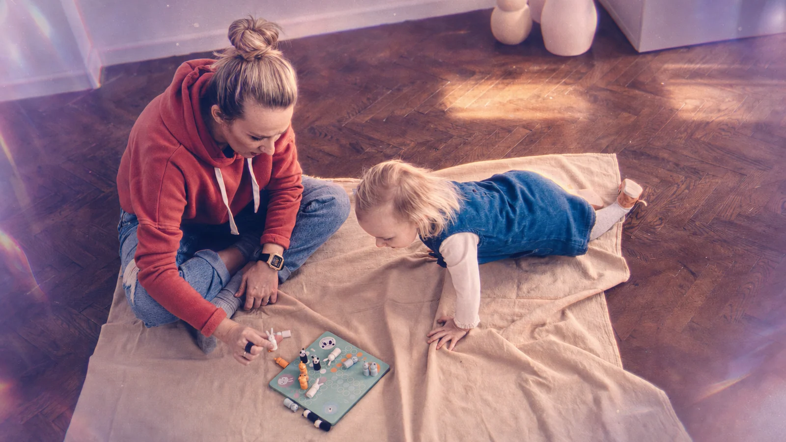 A mother and toddler playing together on the living room floor