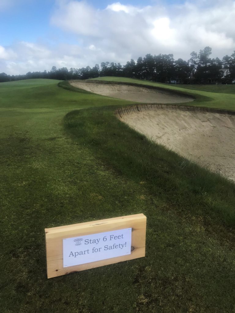 A sign that says, "Stay 6 Feet apart for safety!" on the 18th hole at GGL