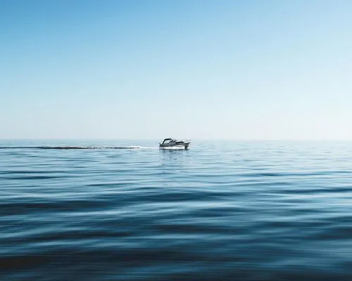 A boat floating on top of a large body of water.