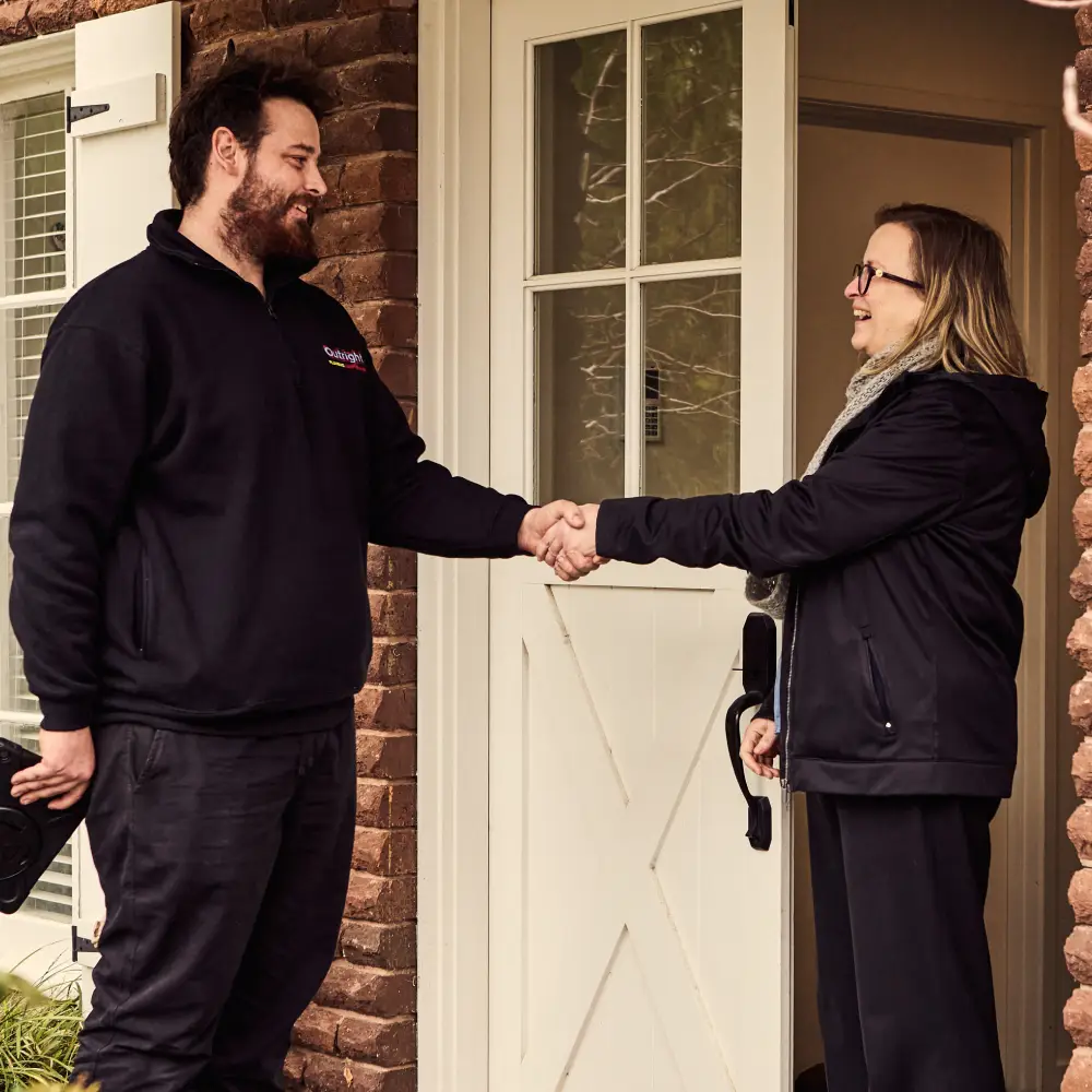 A happy customer shaking the hand of the plumber