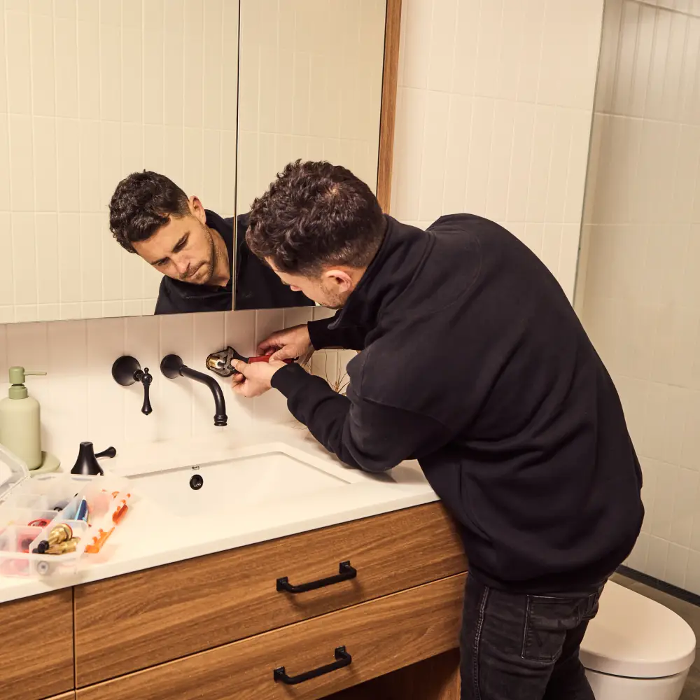 plumber fixing a leaking tap