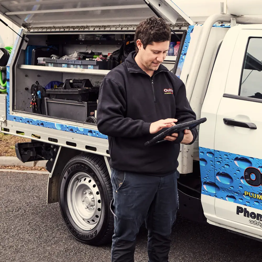 A plumber standing beside a service truck getting ready to perform plumbing service