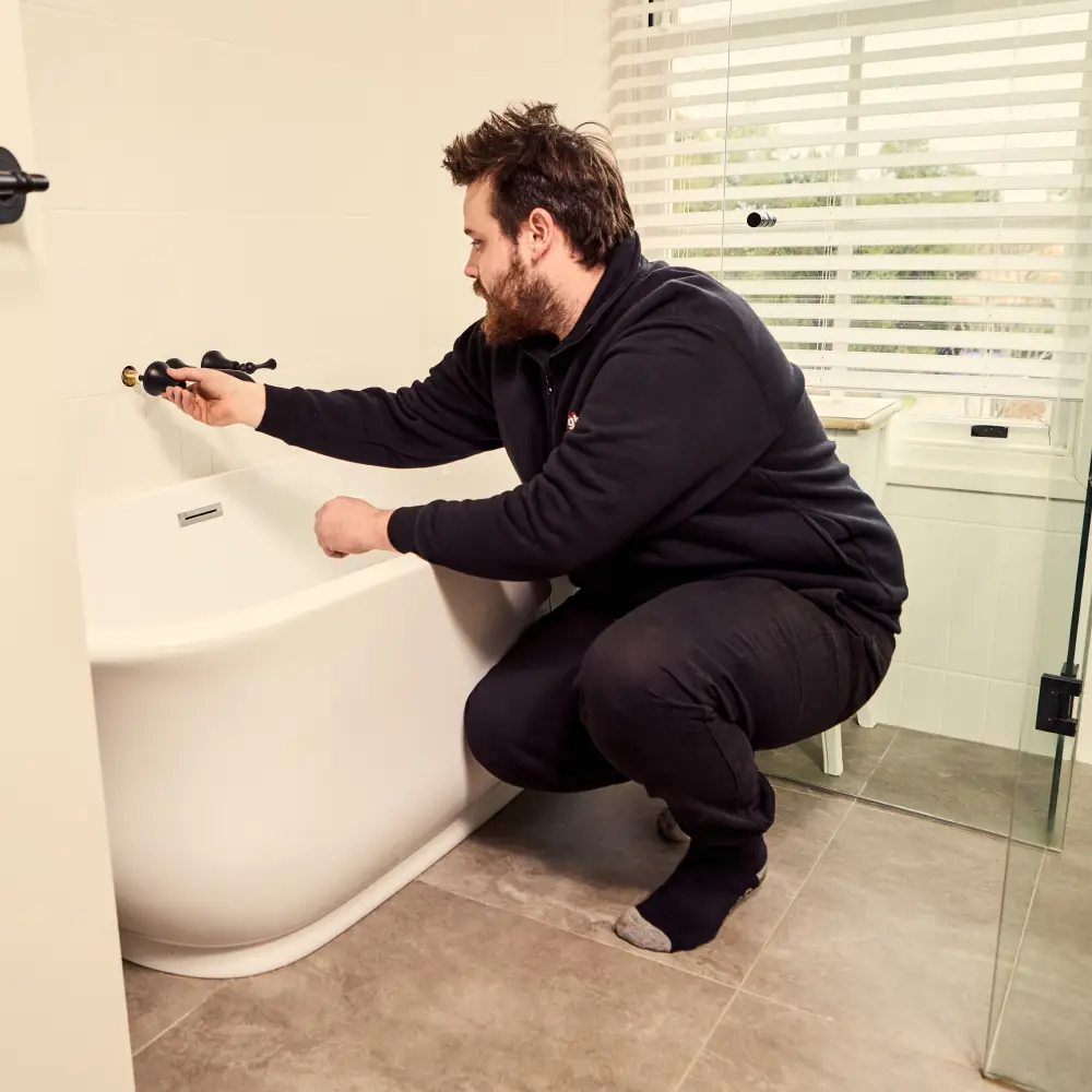 Plumber fixing a water tap in the bathroom