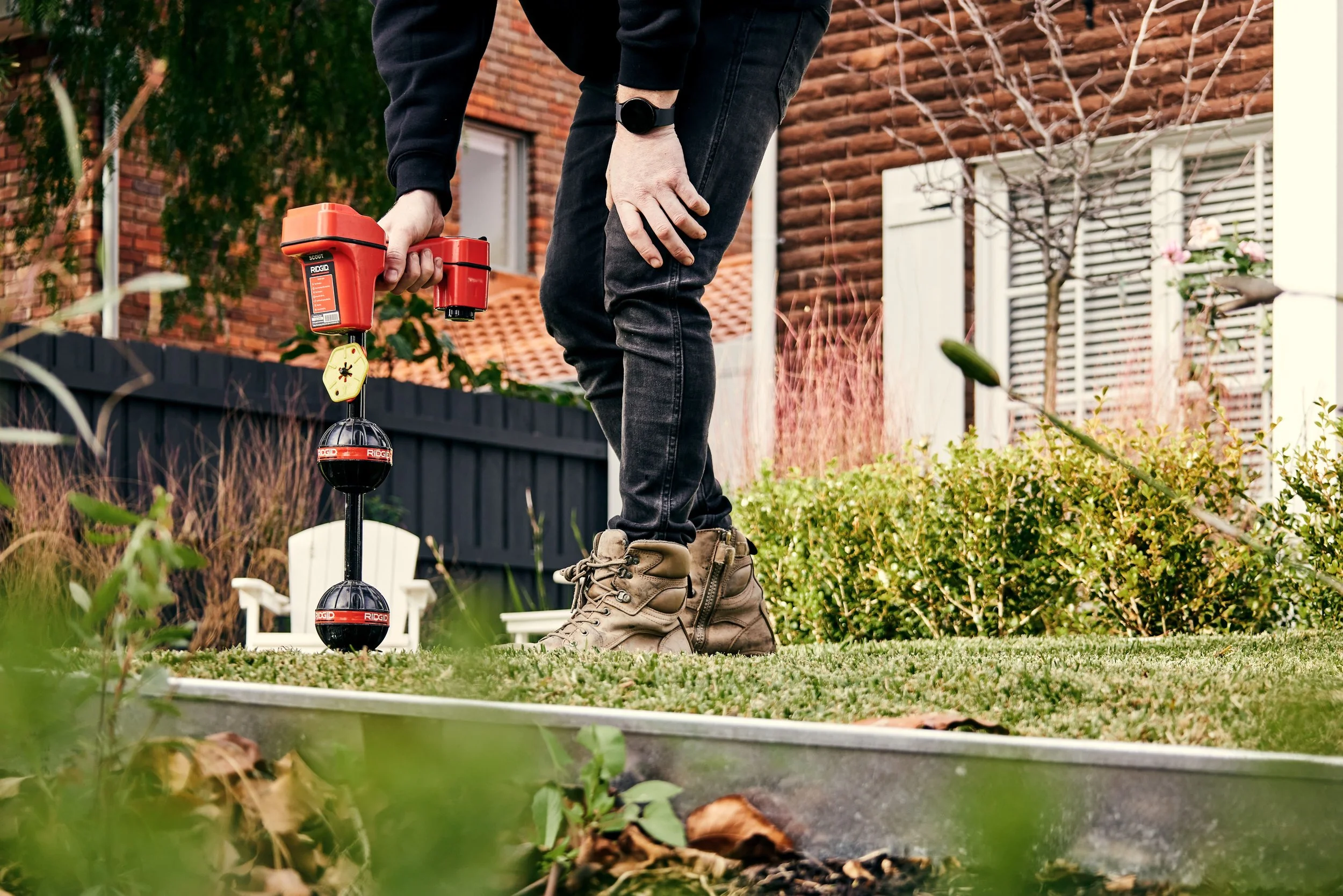 A photo of an Outright Plumbing staff fixing water pipes in the lawn