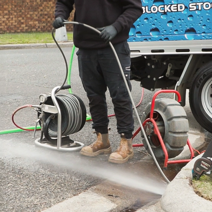 A plumber fixing a sewer drain outside the client's house