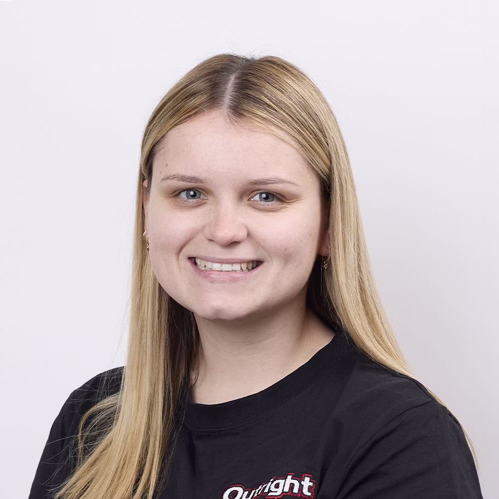 A photo of Hayley in an Outright Plumbing uniform in a standing position