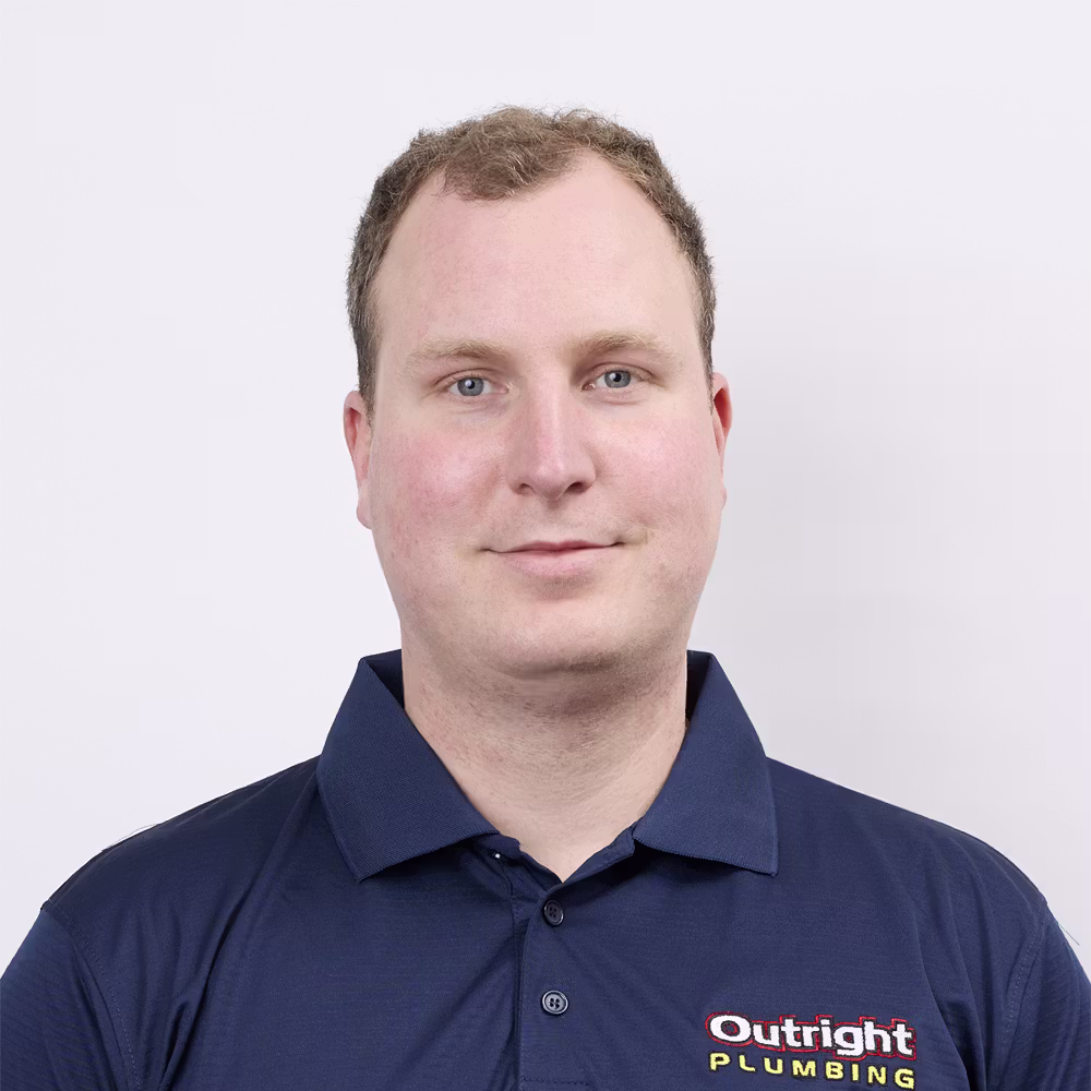 A photo of Ben in an Outright Plumbing uniform in a standing position