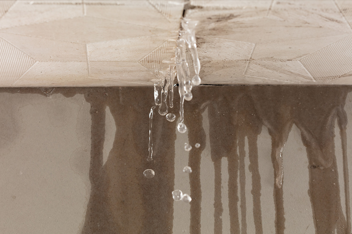 Water streaming through a cracked roof tile. The exact kind of roof plumbing problem Outright Plumbing is called on to fix.