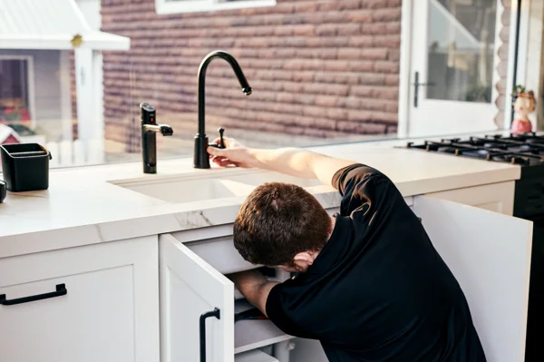 Plumber repairing leaking tap