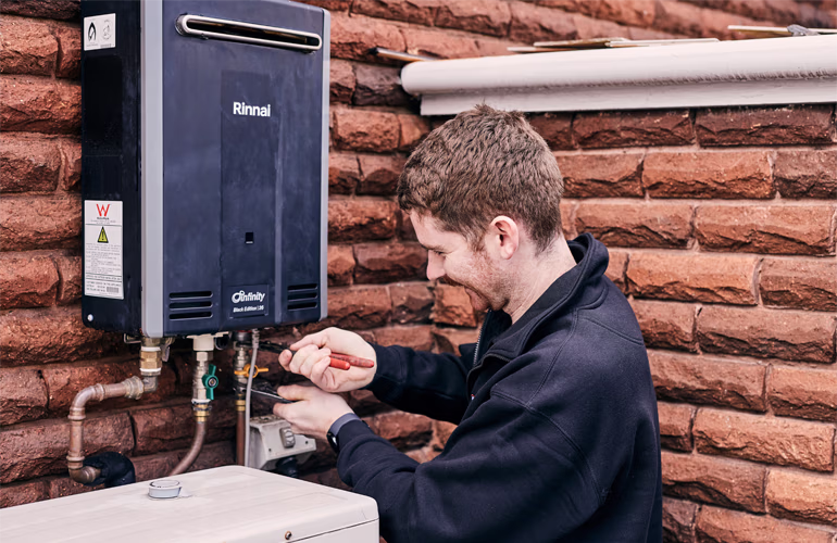 Outright Plumbing staff member working on a hot water system