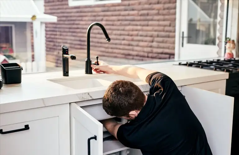 Outright Plumbing staff member installing a new tap in a sink