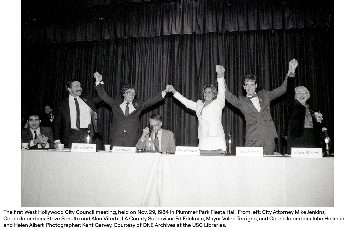 The first West Hollywood City Council meeting, held on Nov. 29, 1984 in Plummer Park Fiesta Hall. From left: City Attorney Mike Jenkins, Councilmembers Steve Schulte and Alan Viterbi, LA County Supervisor Ed Edelman, Mayor Valeri Terrigno, and Councilmembers John Heilman and Helen Albert. Photographer: Kent Garvey. Courtesy of ONE Archives at the USC Libraries.
