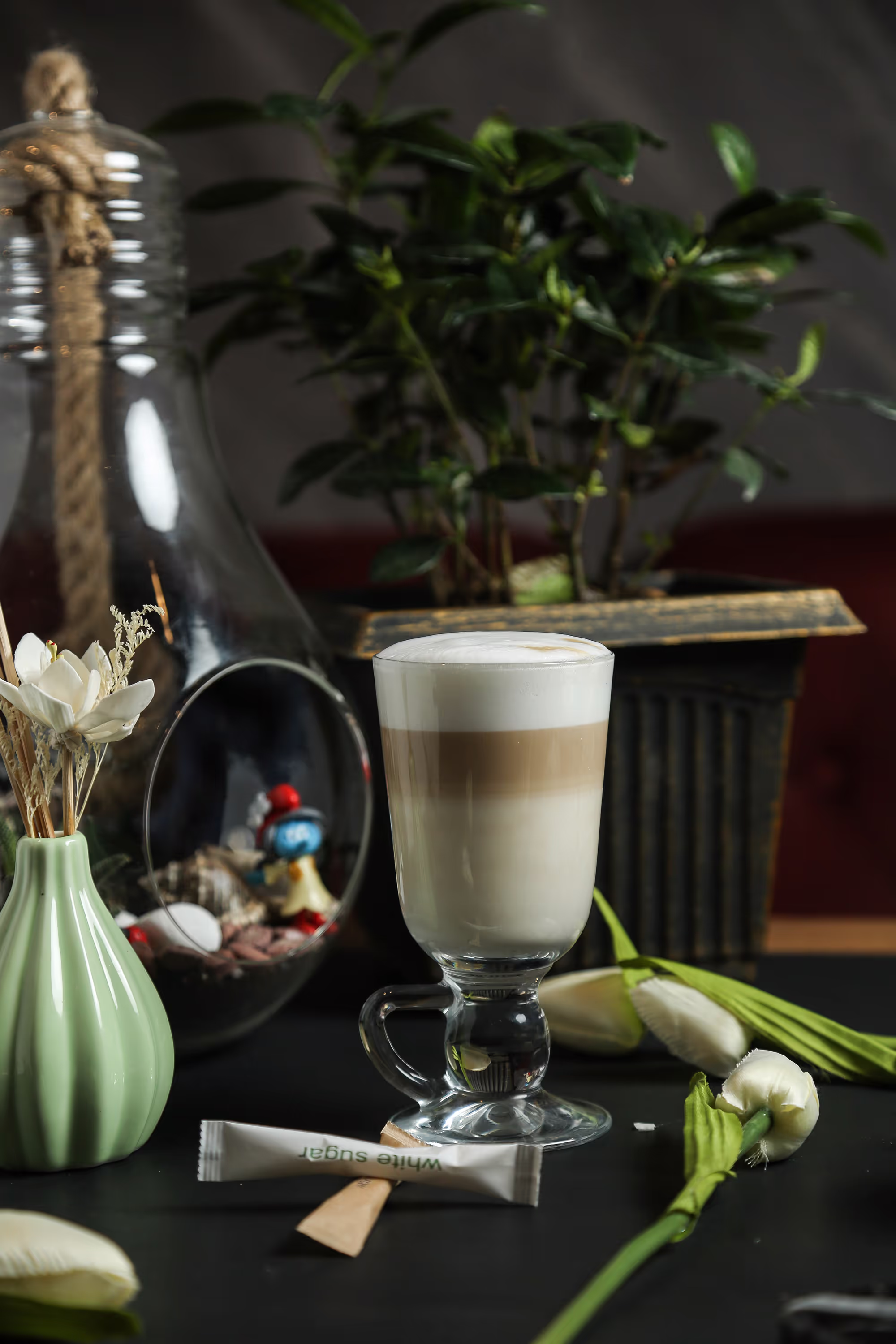 Layered latte in glass with flowers and plants
