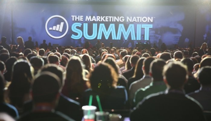 Image of Marketo's Marketing Nation logo with people networking and collaborating in the background, representing a thriving community of marketers