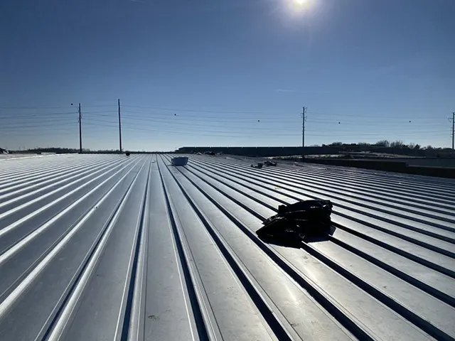 View of a metal commercial roof under clear skies during a professional roof inspection in Southlake, Texas.