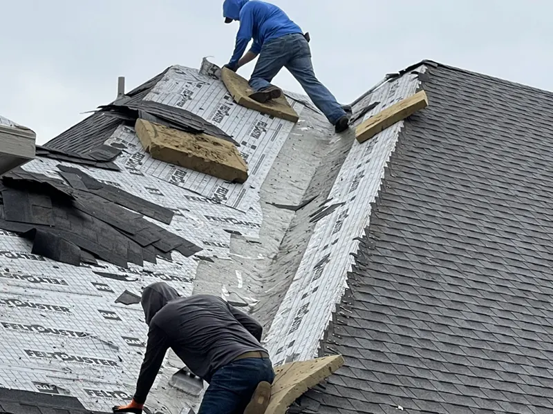 Roofing contractors installing impact-resistant shingles, enhancing home protection against hail and wind damage.