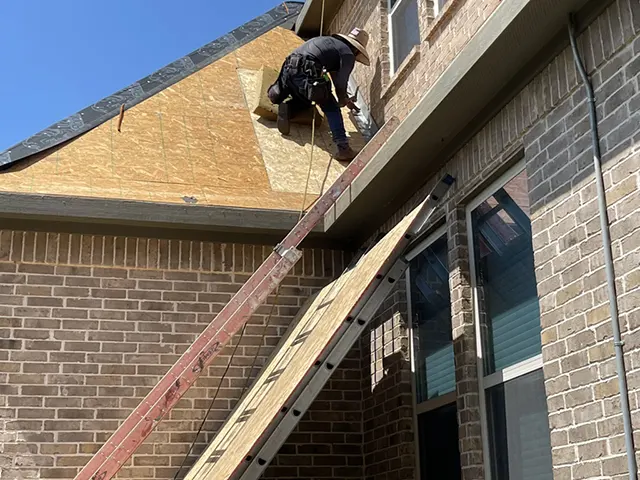 CLC Roofing crew member installing stone-coated steel roofing underlayment on a residential home in Southlake, TX.