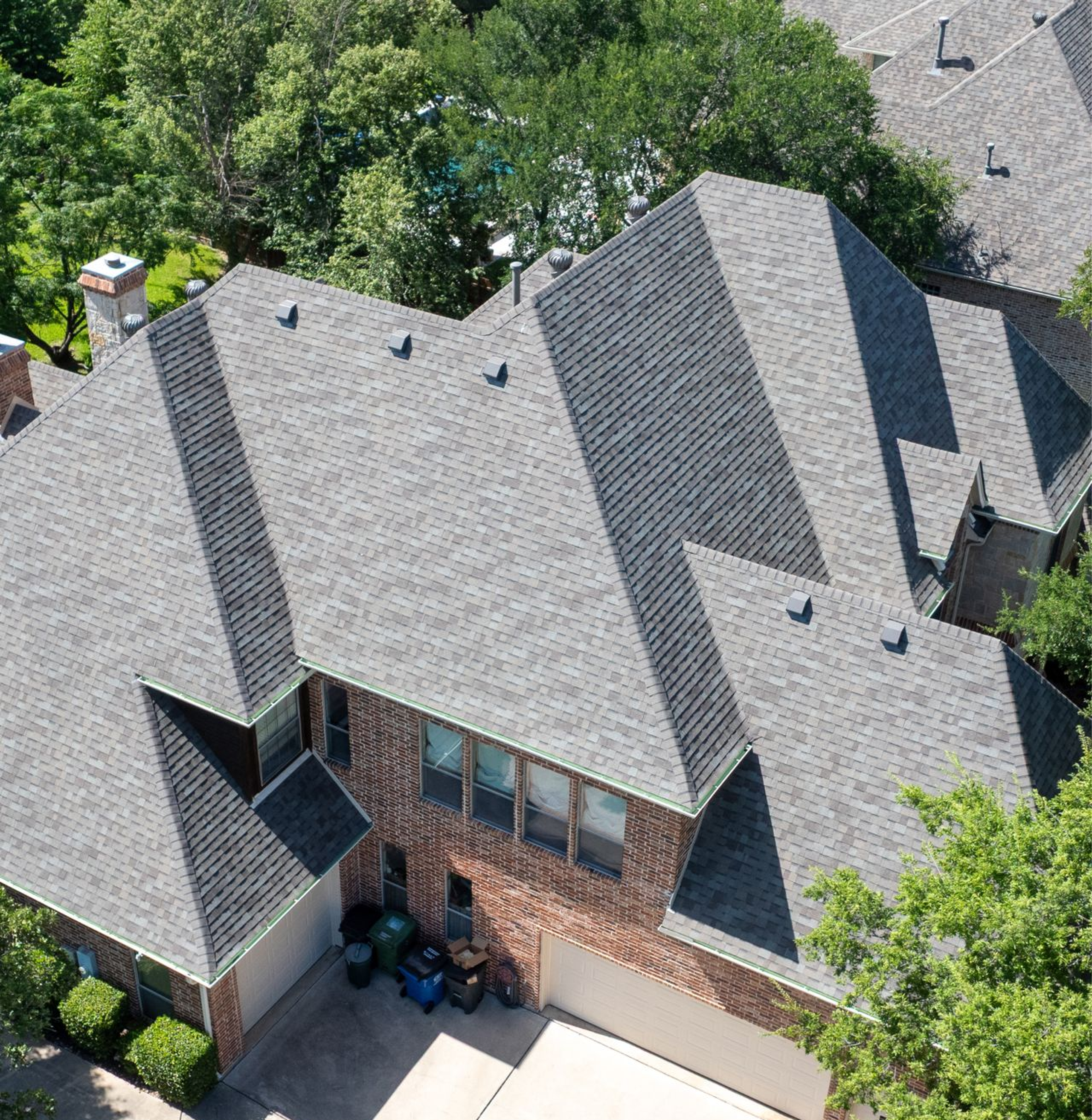 Aerial view of newly installed asphalt shingle roof on a two-story home in Southlake TX