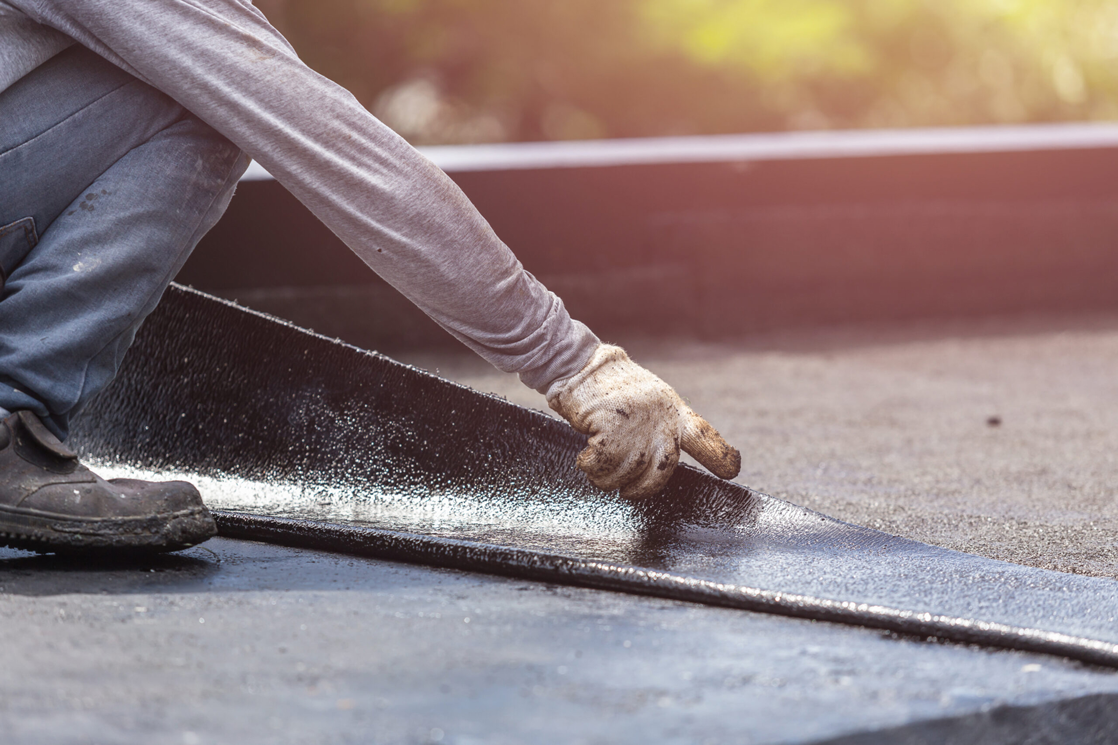 Roofer installing flat roofing membrane with precision for commercial property in Southlake TX
