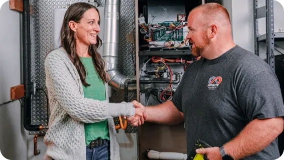 A technician shakes hands with a homeowner after a successful HVAC service visit.