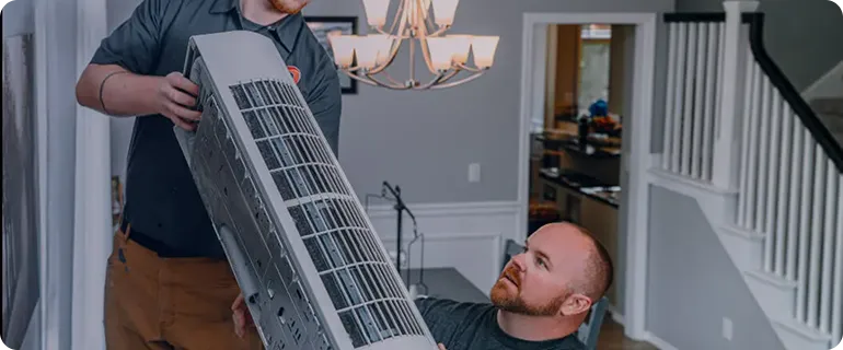 Technicians installing an HVAC unit in a modern home living room.