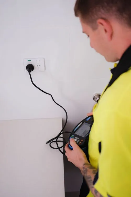 An electrician testing a power socket