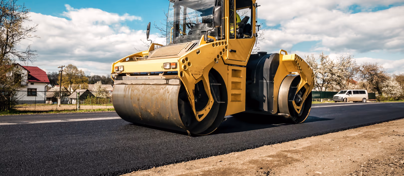 Asphalt roller paving commercial driveway for resurfacing and lot improvement project