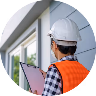 Engineer in safety helmet examining building exterior, representing customized facility maintenance solutions