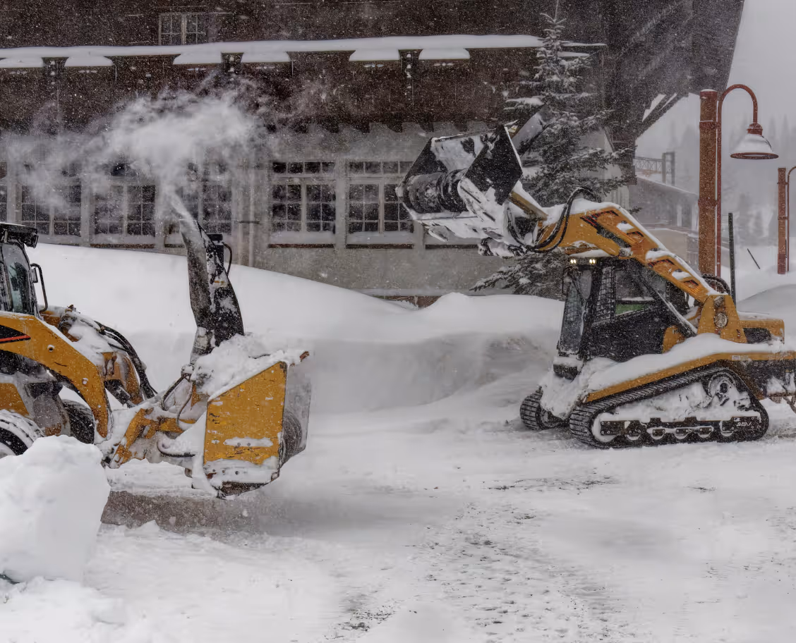 Commercial snow removal equipment clearing icy lot for safe winter access and property safety