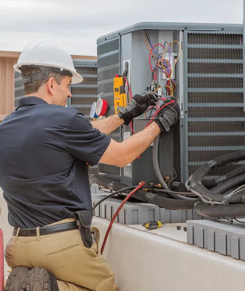 HVAC technician servicing rooftop air conditioning unit for seasonal facility maintenance