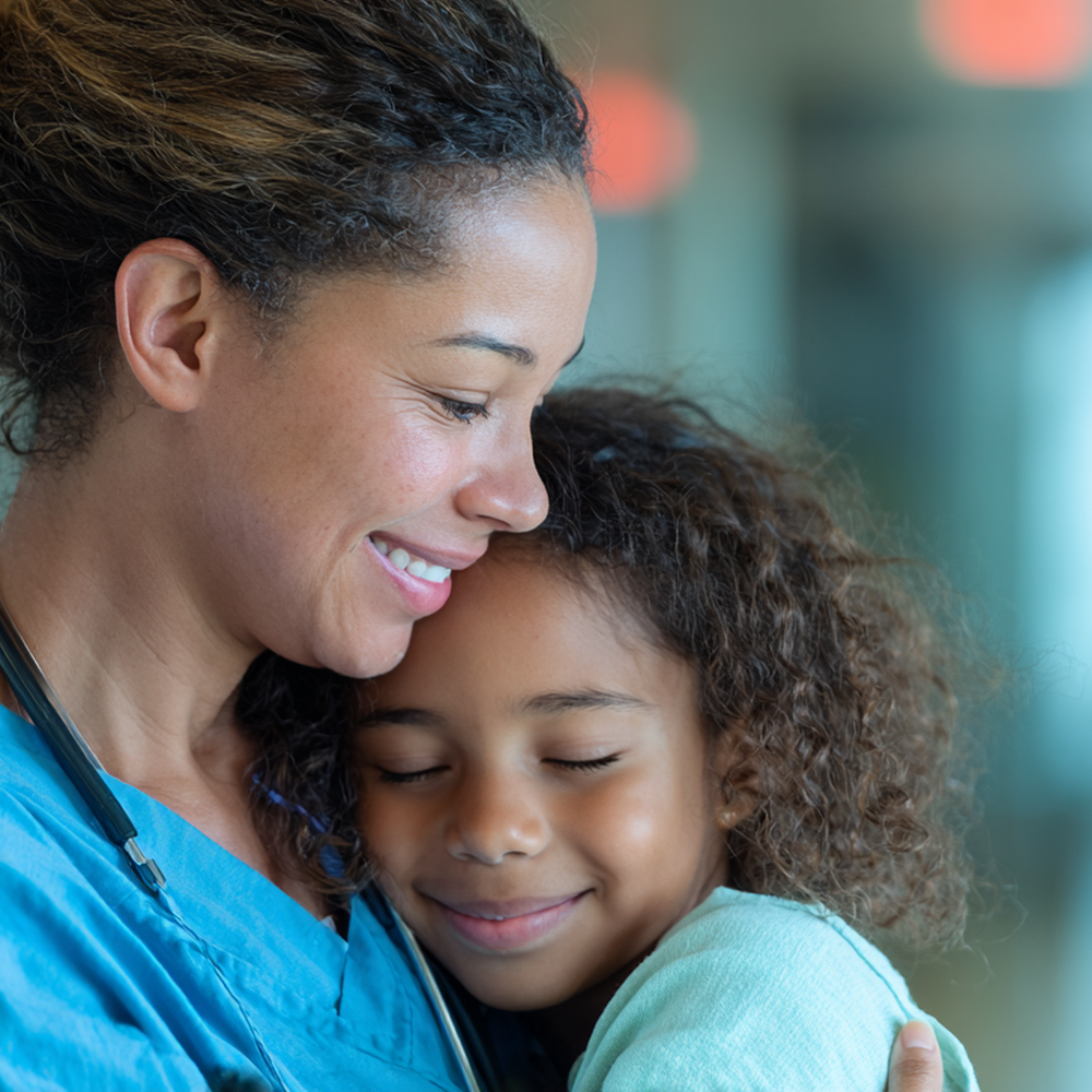 Close-up of two people hugging with eyes closed and gentle smiles, showing tenderness and connection.