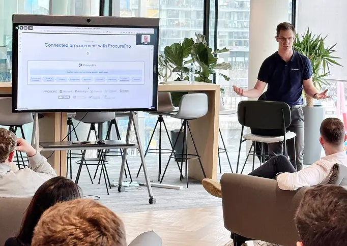 Procurepro CEO Alastair Blenkin speaking at the Procore HQ in front of a presentation