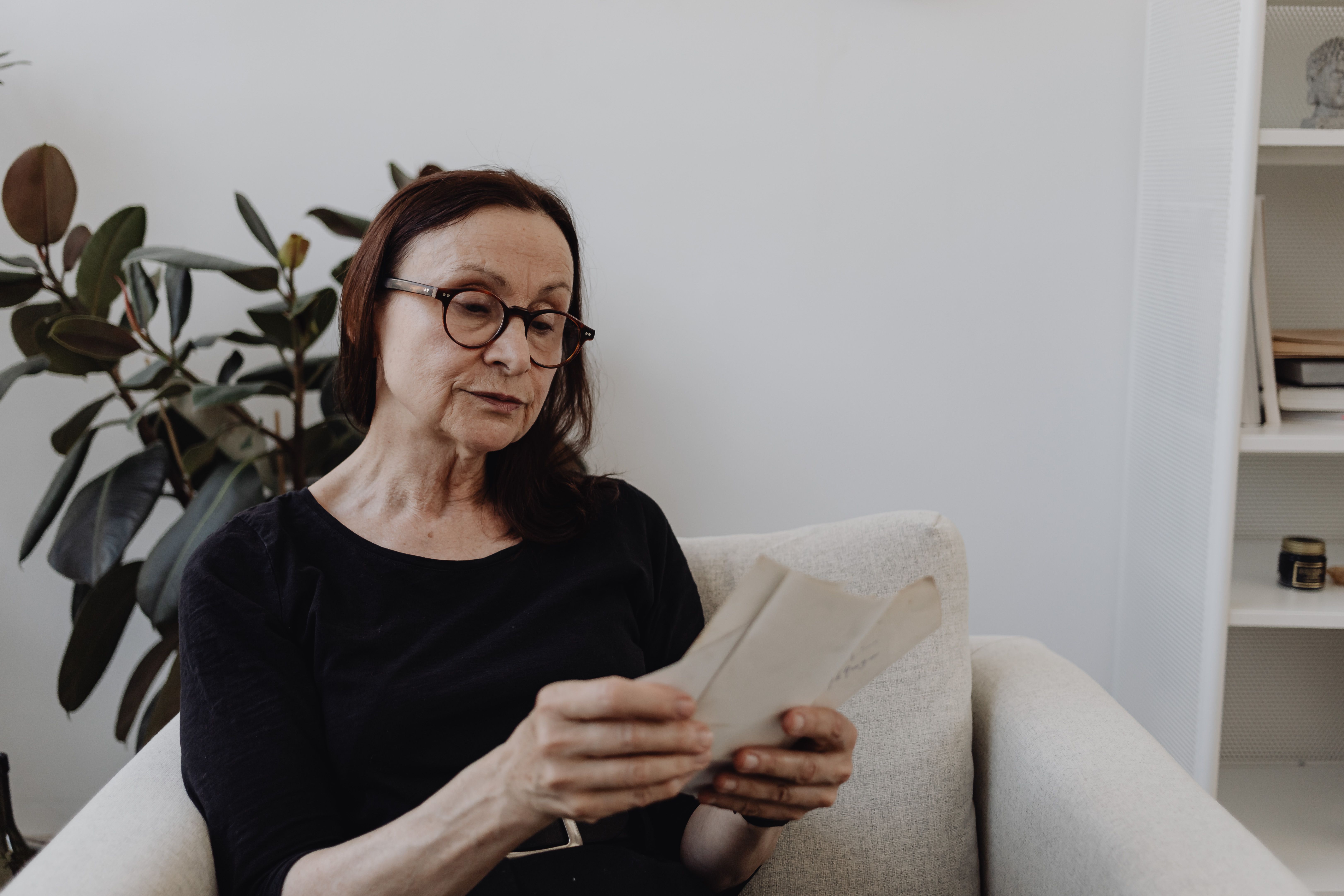 Betreuungskraft und Seniorin besprechen den Pflegegrad am Wohnzimmertisch, dokumentiert mit HeyCarla
