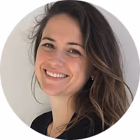 Smiling woman with long brown hair wearing a black top against a light background.