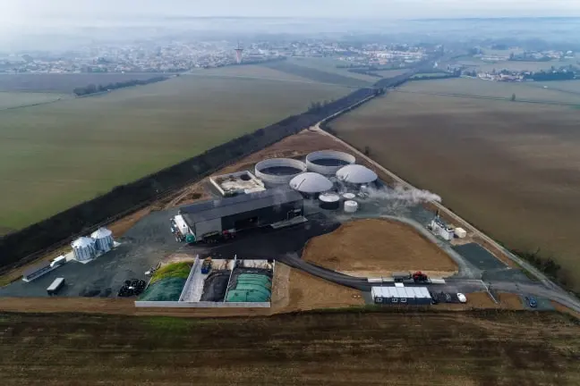 Aerial view of an industrial facility with large storage tanks and buildings surrounded by agricultural fields.