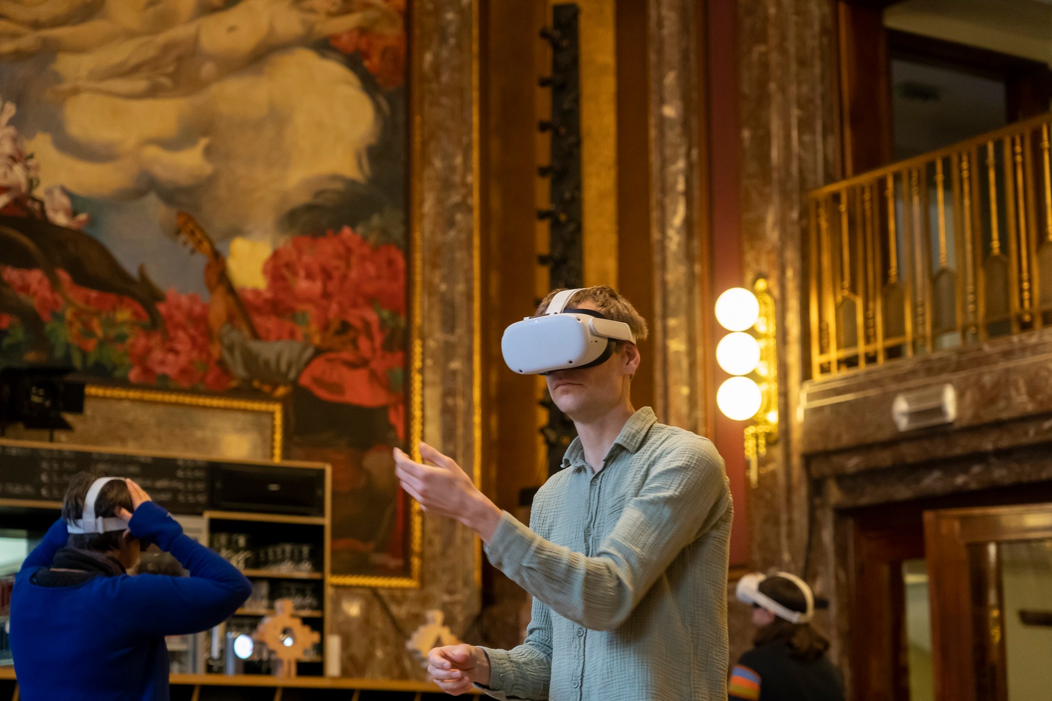 Een jonge man loopt rond met een VR-bril op in de foyer van de schouwburg in Leuven.