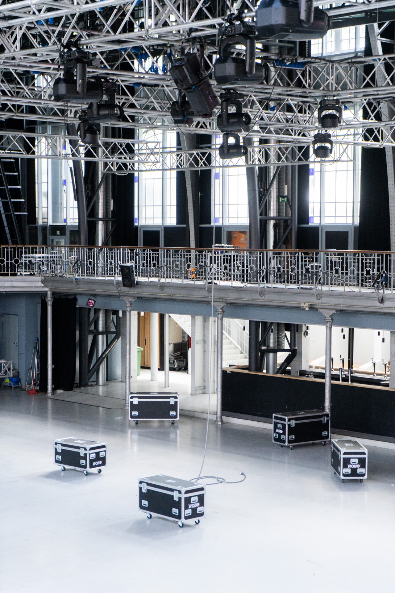 Interior of Les Halles with a lighting rig and black flight cases on the floor.