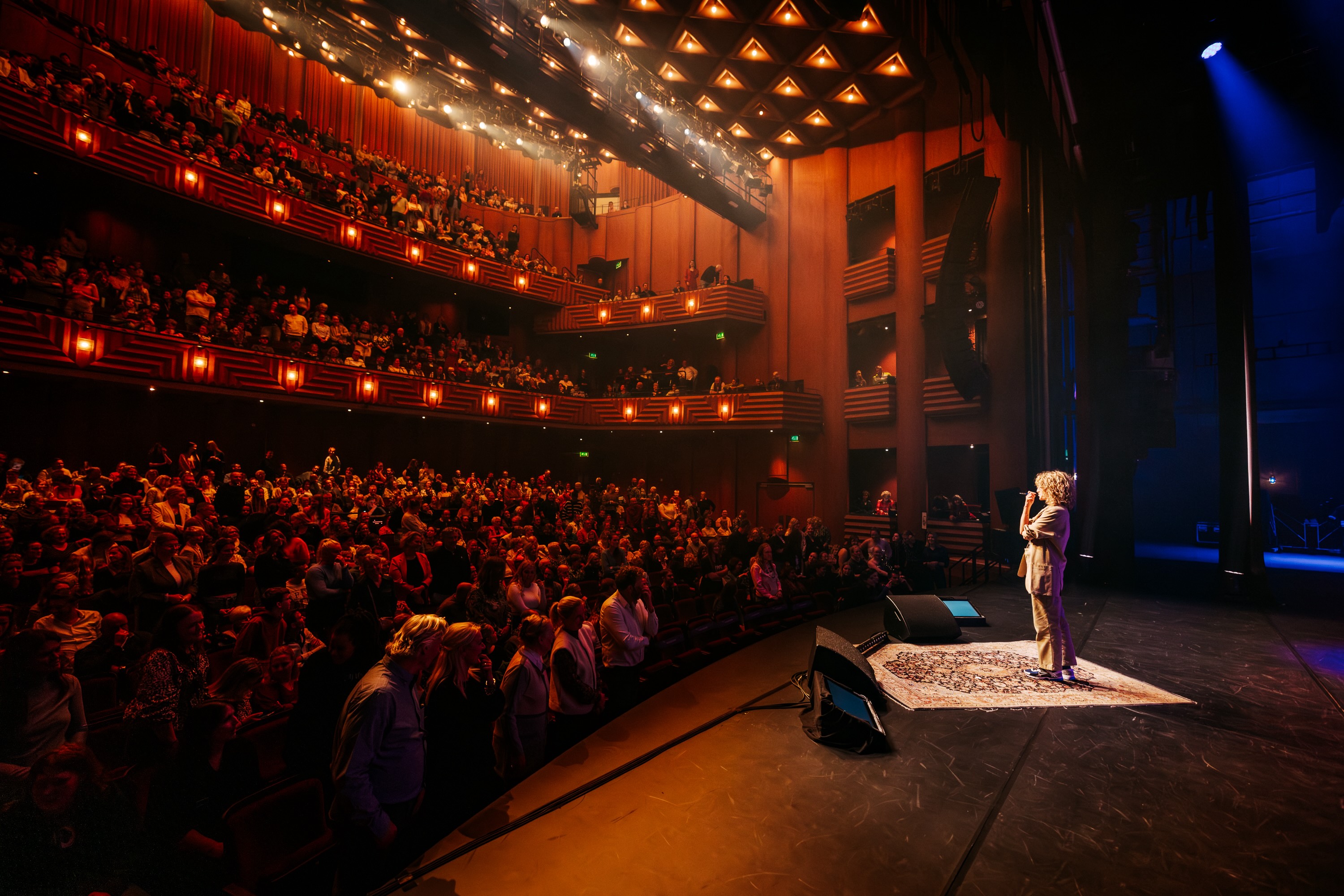 Packed auditorium at Theater de Spiegel in Zwolle with a speaker on stage