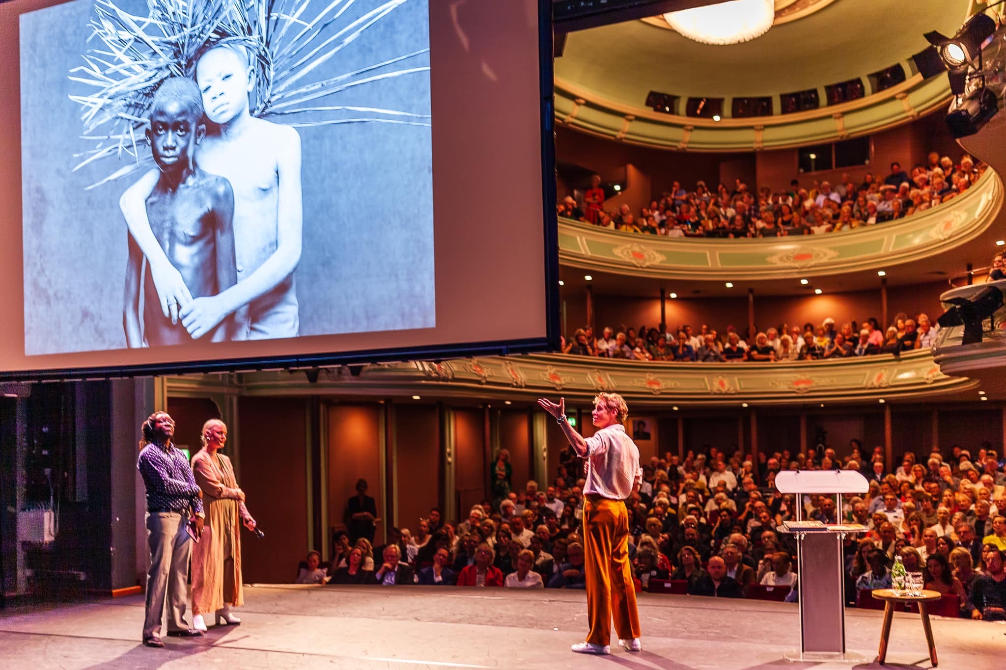 Audience and stage in the Hanzestrohmzaal at Schouwburg Odeon during a presentation
