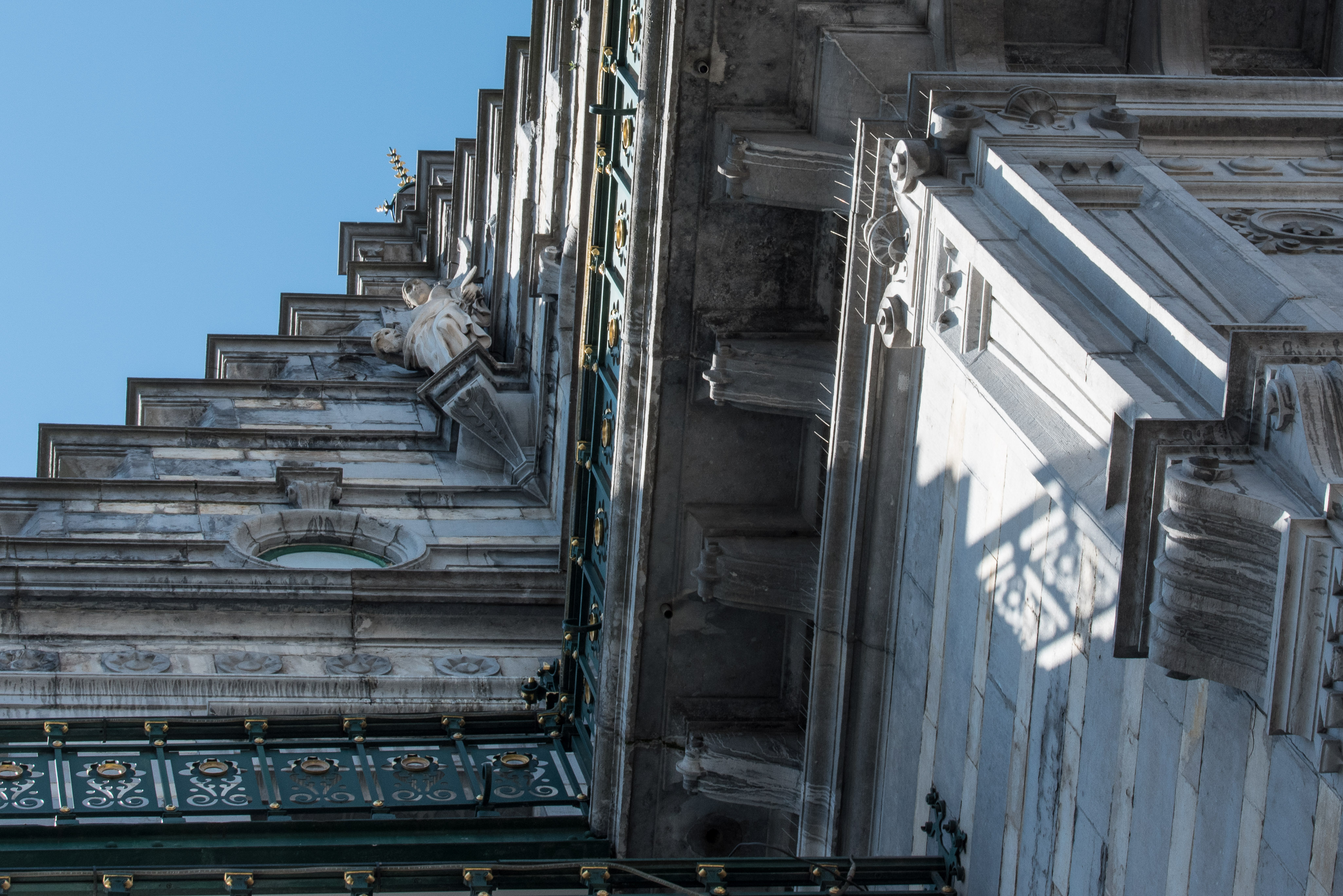 Detail of the historic KVS façade in Brussels against a clear blue sky.