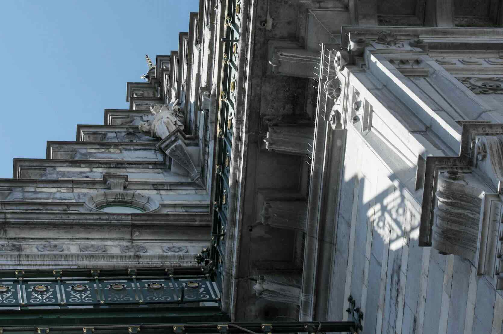 Détail de la façade historique du KVS à Bruxelles sous un ciel bleu dégagé.