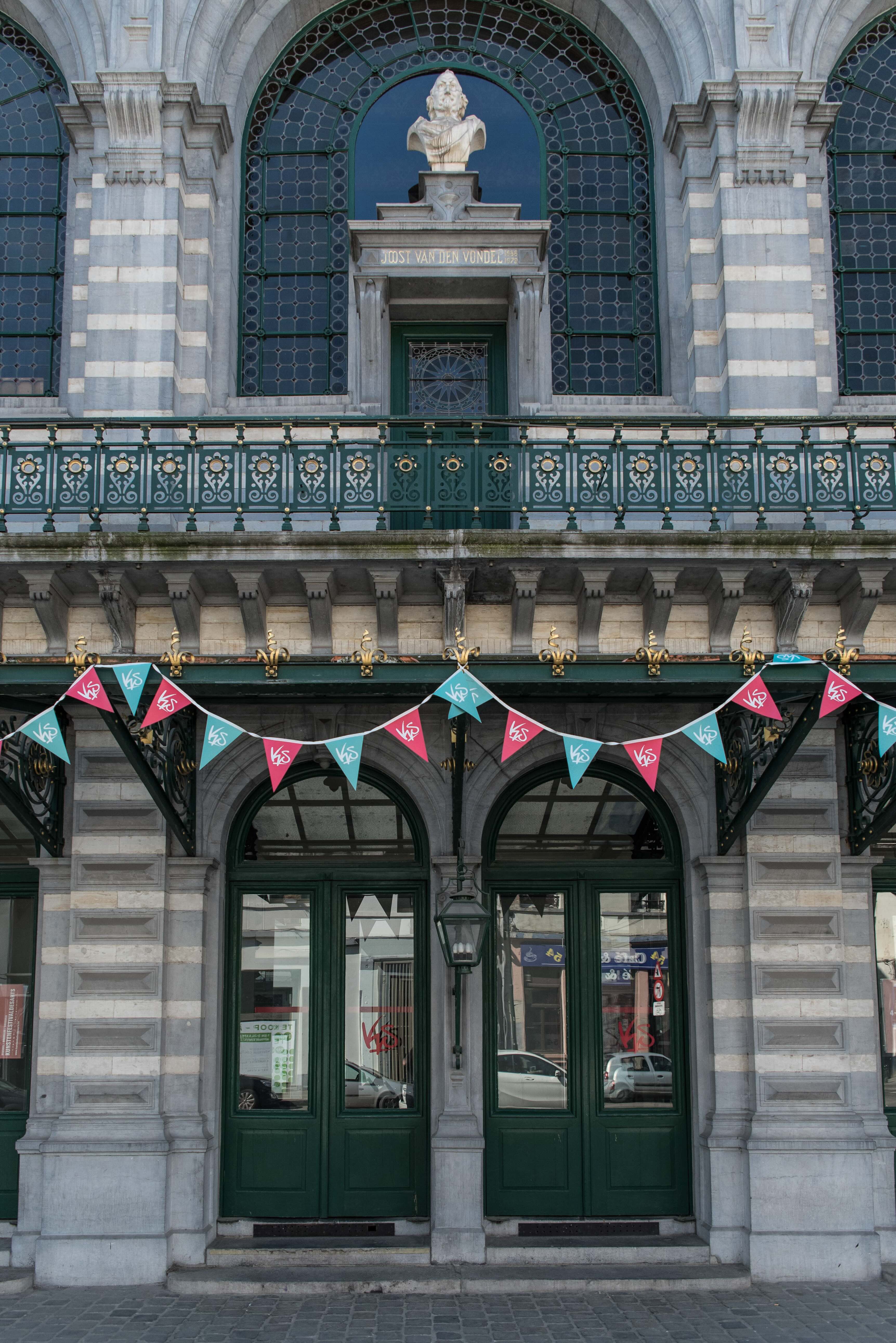 Main entrance of KVS in Brussels, decorated with colorful KVS pennant flags.