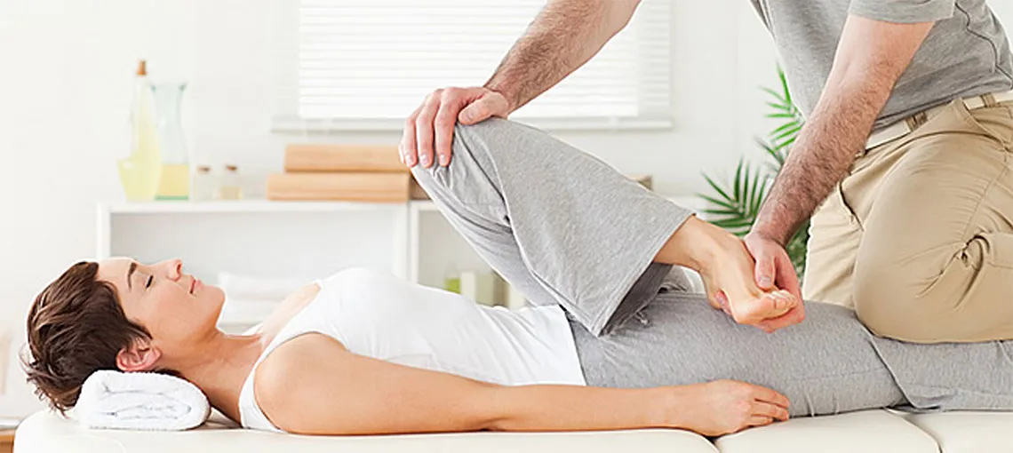 therapist stretching female patient's hip